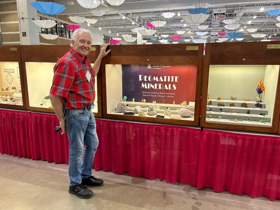 Museum Advisory Council member Les Presmyk standing next to our display case at the Tucson Convention Center.
